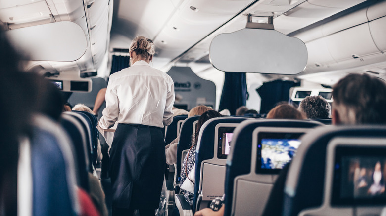 flight attendant on crowded airplane