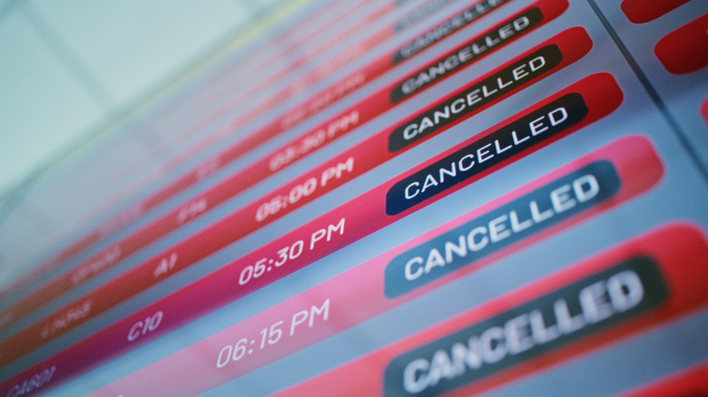 An airport flight information board showing cancelled flights.