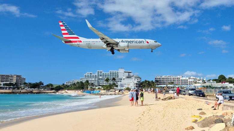 A plane coming in for a landing over the beach at Princess Juliana Airport.