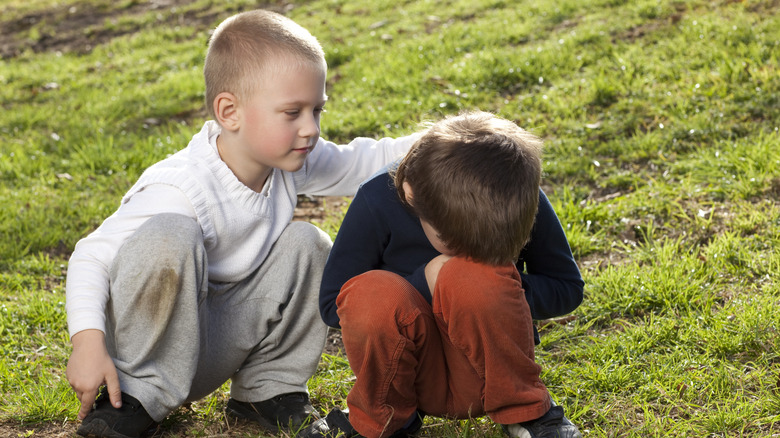 child crying with friend comforting them