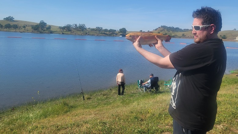 person holding large fish on the side of Lake McSwain near Snelling, California