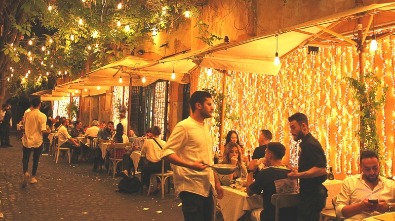 evening diners at outdoor tables of restaurant in Italy