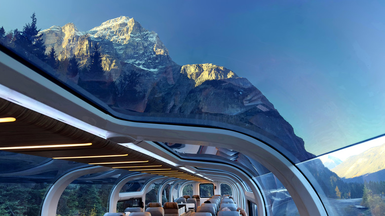 Close-up POV shot looking out through a glass-topped train onto majestic snowcapped mountains of the Canadian Rockies