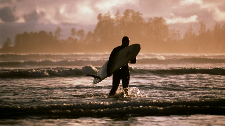 Surfer exiting the surf at Pacific Rim National Park Preserve