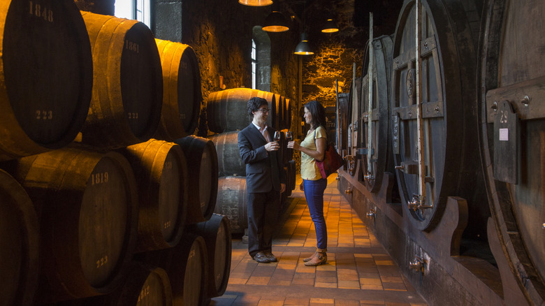 Couple enjoying a port wine tasting in cellar of Burmester winery