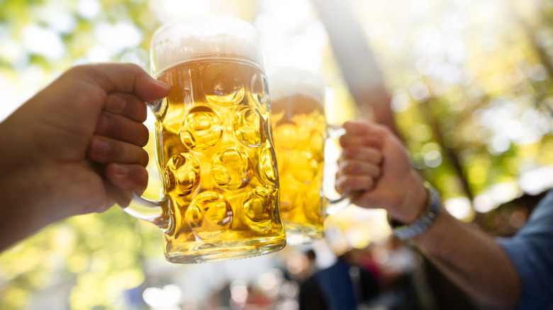 Two people clinking a glass outside in a German beer garden