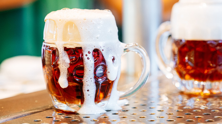 Fresh beer overflowing a traditional German mug