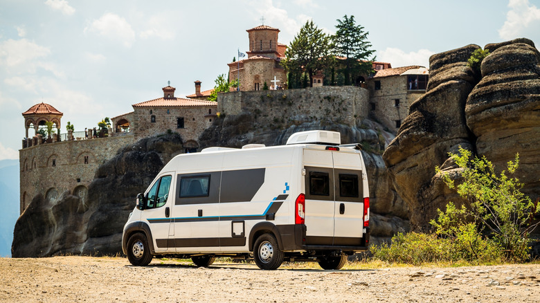 Meteora monastery in Greece with a campervan RV parked in the parking lot