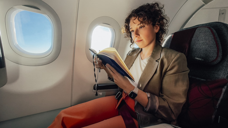 A relaxed airline passenger reading a book
