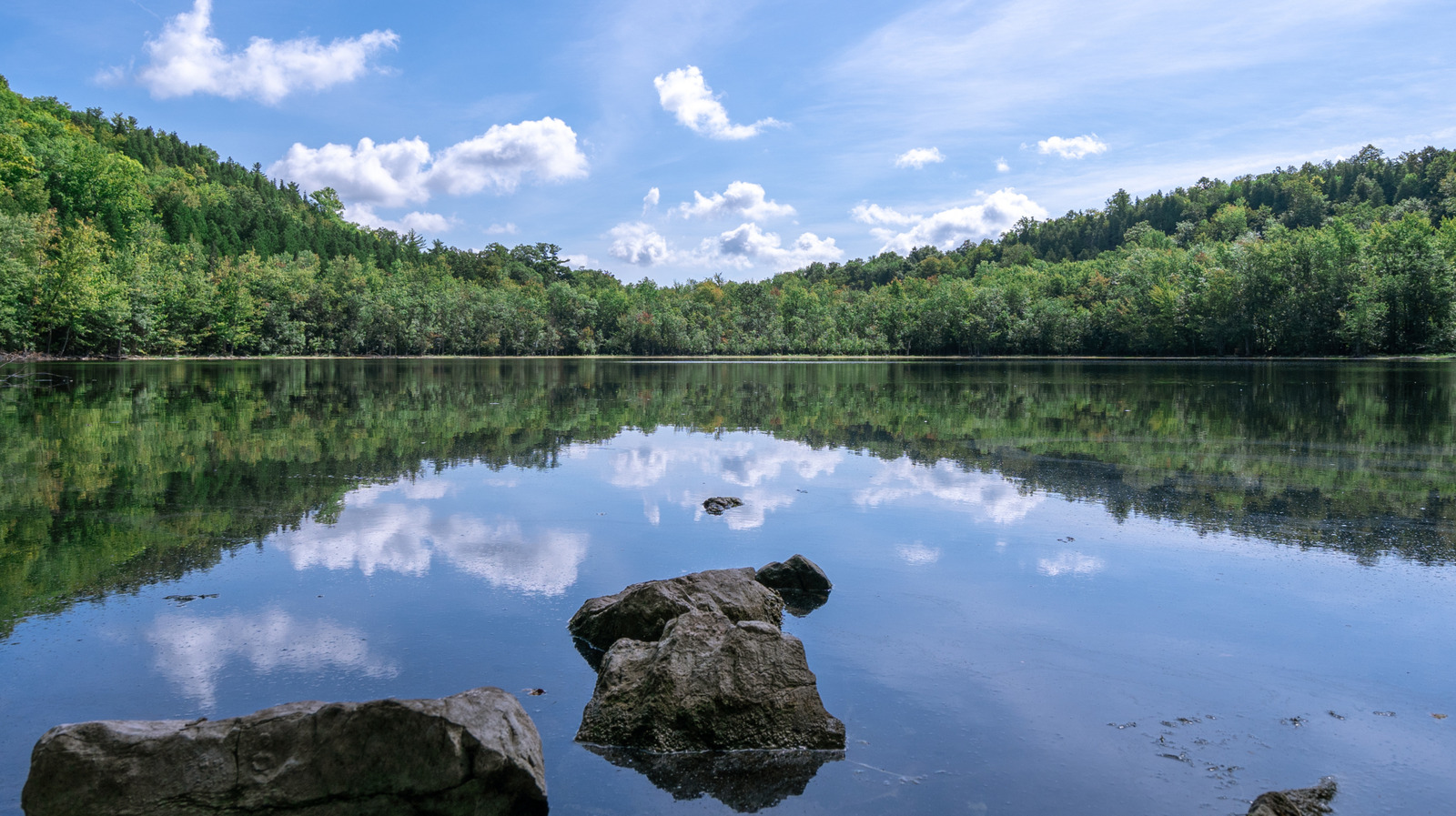 New York's Serene State Park Boasts A Glassy Plunge Pool Lake With Rugged Trails And Fall Colors

